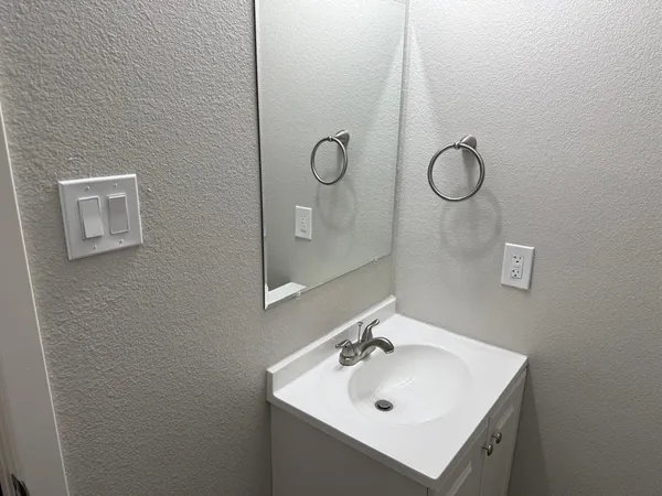 a bathroom with a sink mirror and vanity
