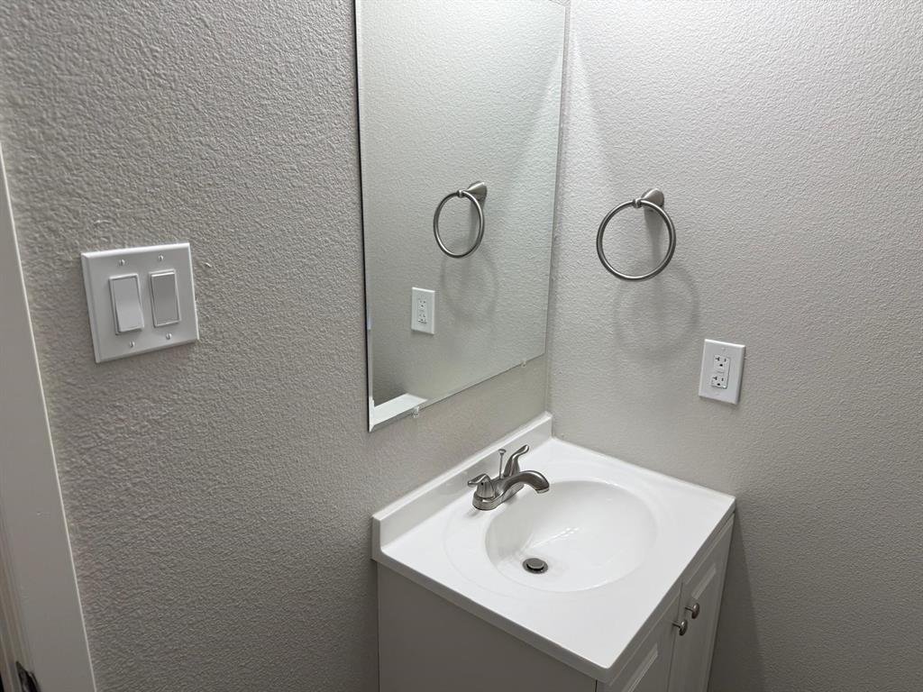 925 Bluewood Drive Dallas, TX 75232 - Photo 14 of 33 a bathroom with a sink mirror and vanity