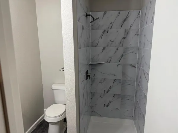 a bathroom with a toilet and a shower