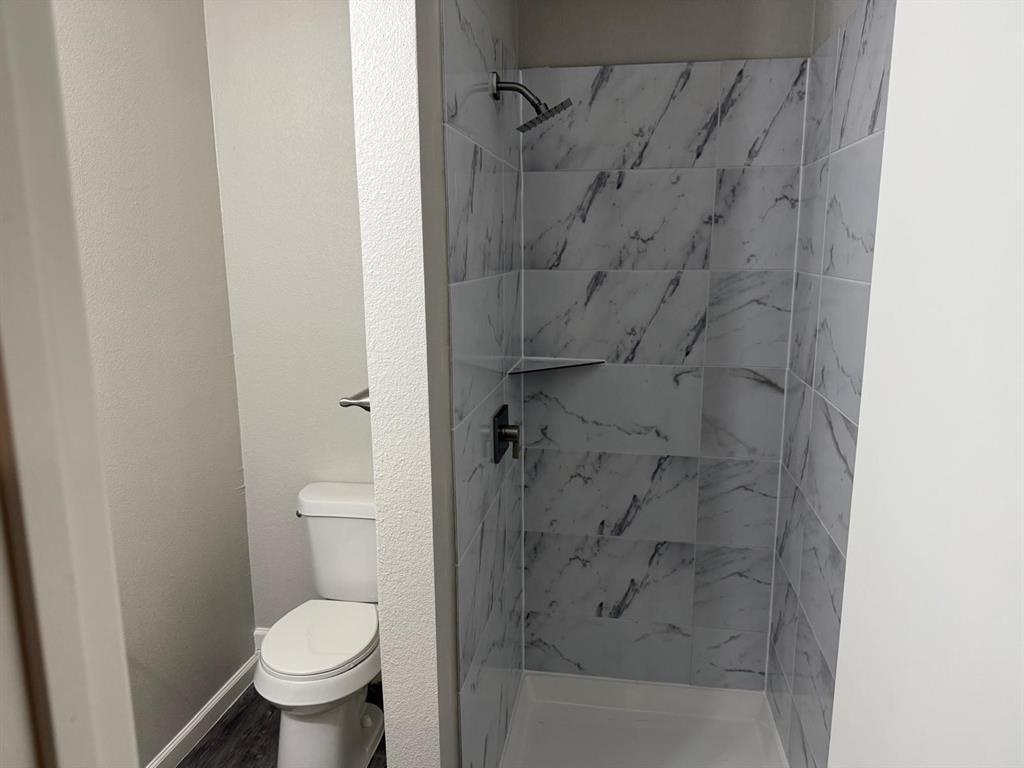 925 Bluewood Drive Dallas, TX 75232 - Photo 17 of 33 a bathroom with a toilet and a shower