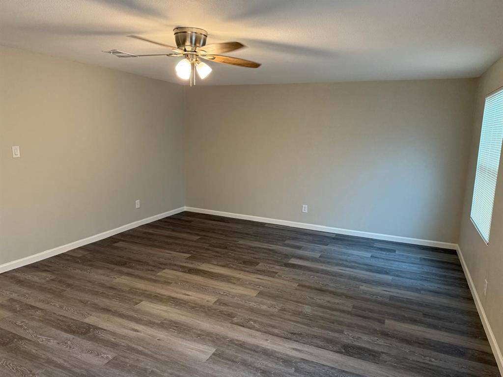 925 Bluewood Drive Dallas, TX 75232 - Photo 19 of 33 a view of a room with wooden floor and a ceiling fan
