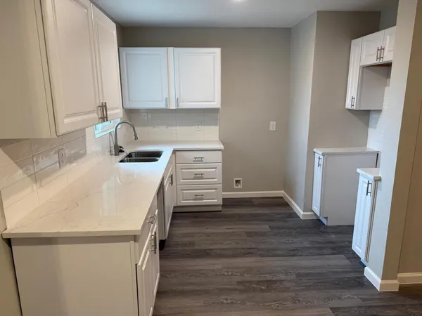 a kitchen with granite countertop a sink and a stove top oven