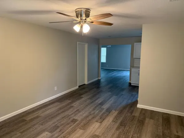 a view of an empty room with wooden floor