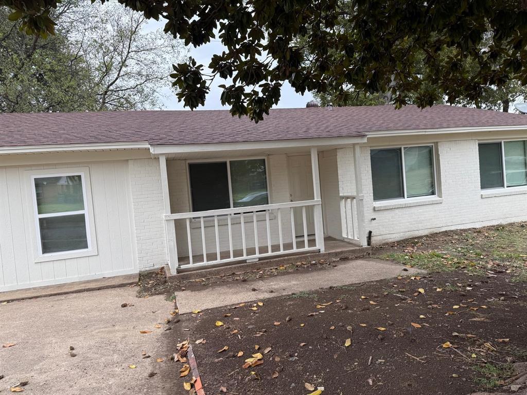 925 Bluewood Drive Dallas, TX 75232 - Photo 31 of 33 View of front facade with roof with shingles, brick siding, and a porch