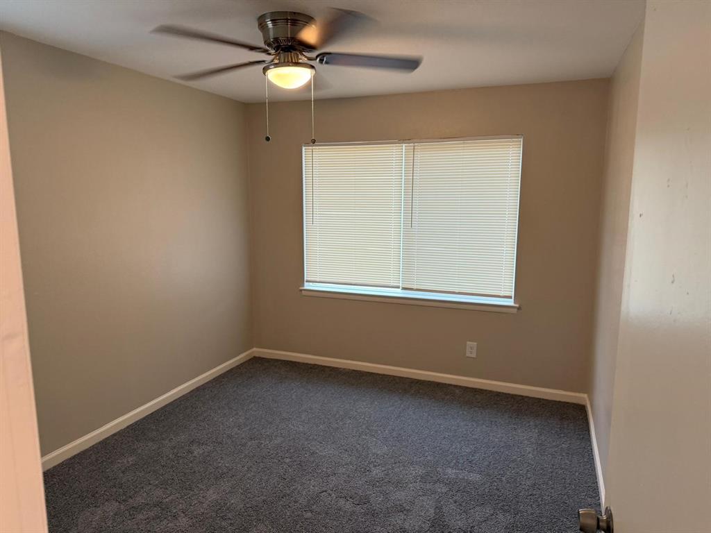 925 Bluewood Drive Dallas, TX 75232 - Photo 4 of 33 an empty room with a window and a fan