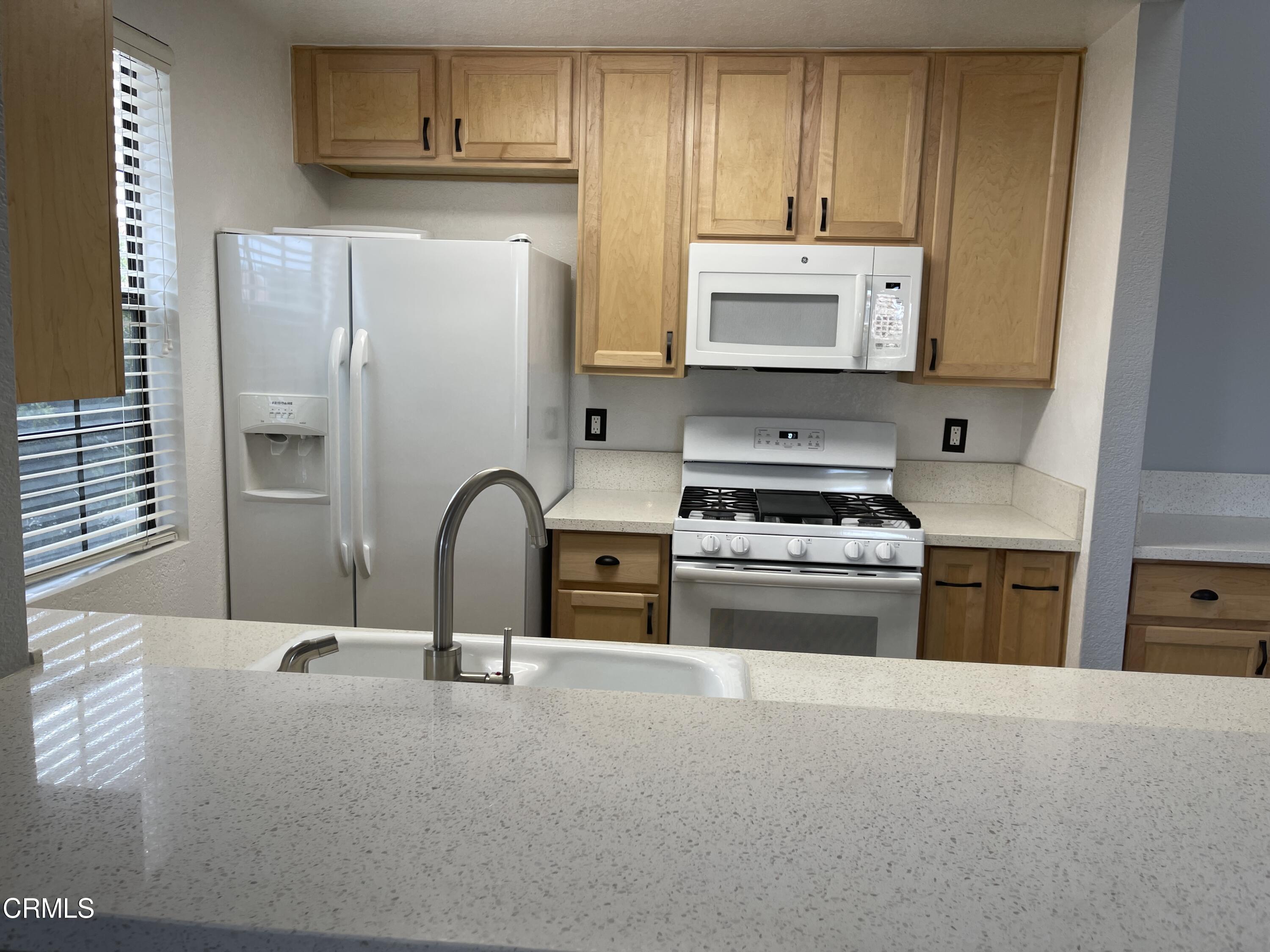 2257 Martinique Lane Oxnard, CA 93035 - Photo 12 of 52 a kitchen with stainless steel appliances granite countertop a stove a sink and a refrigerator
