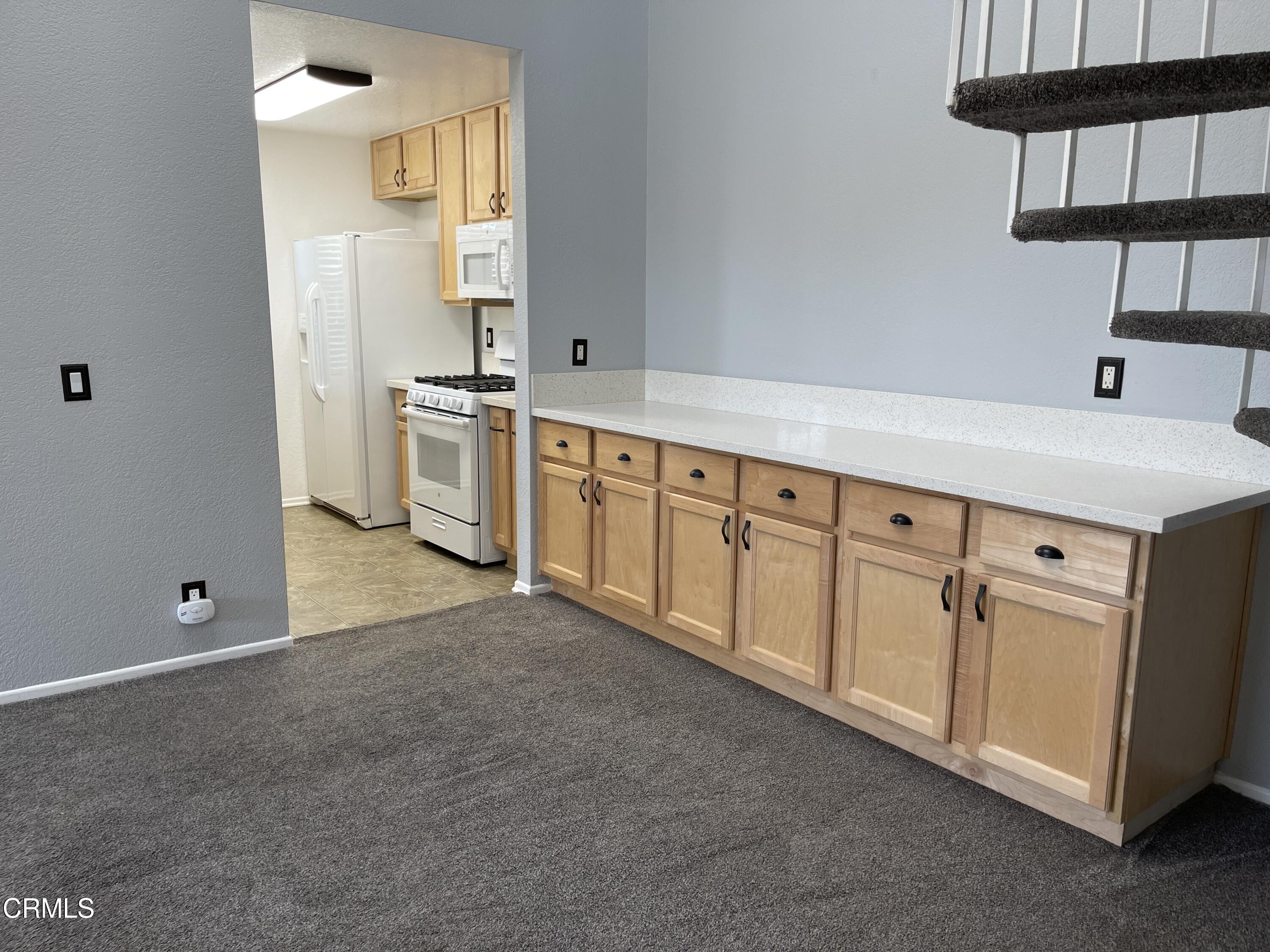 2257 Martinique Lane Oxnard, CA 93035 - Photo 14 of 52 a kitchen with granite countertop white cabinets and white appliances