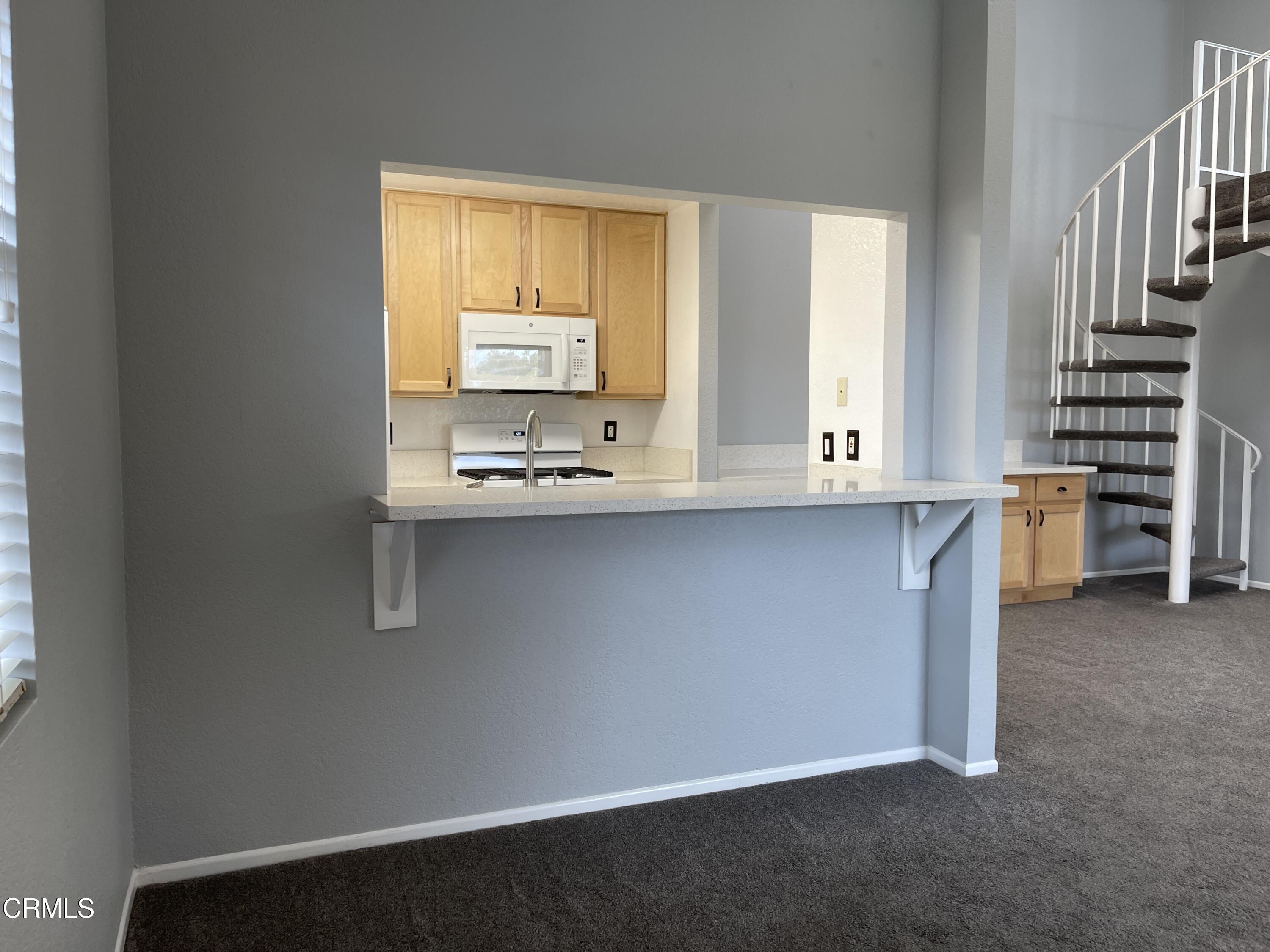 2257 Martinique Lane Oxnard, CA 93035 - Photo 7 of 52 a kitchen with kitchen island a sink appliances cabinets and a window