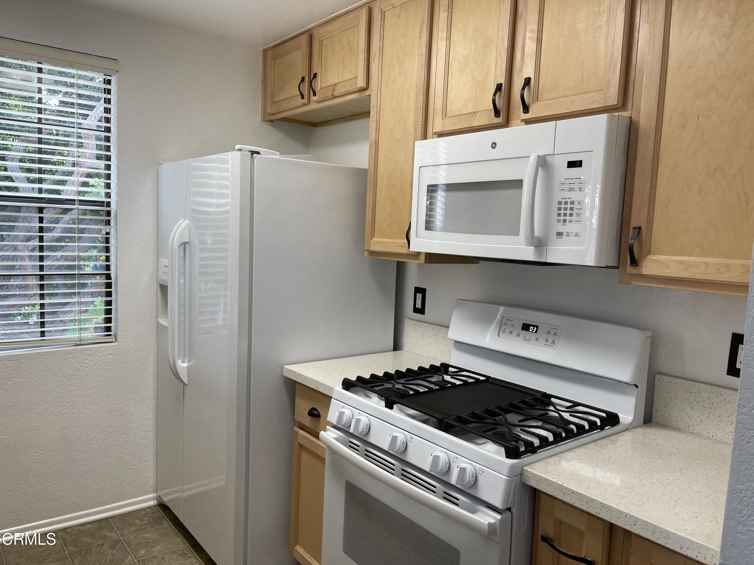 2257 Martinique Lane Oxnard, CA 93035 - Photo 9 of 52 a kitchen with stainless steel appliances granite countertop a stove and a microwave