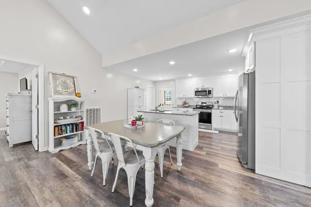 a kitchen with stainless steel appliances kitchen island granite countertop a refrigerator and a stove top oven