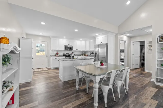 a living room with furniture a two couches and a dining table with wooden floor