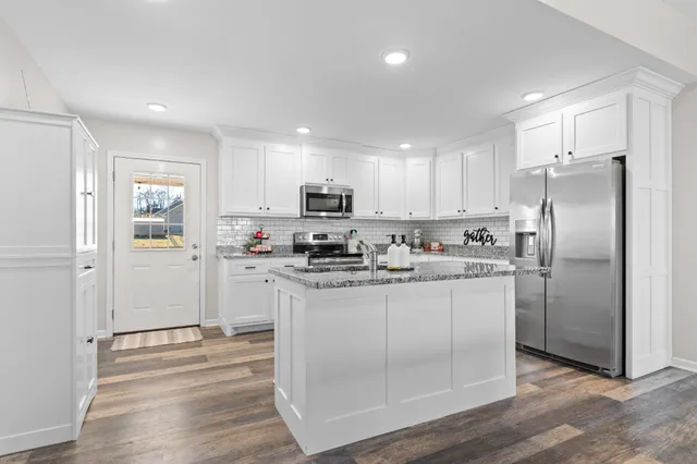 a kitchen with stainless steel appliances granite countertop a sink and refrigerator