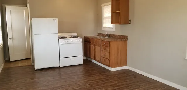 a utility room with wooden floor washer and dryer