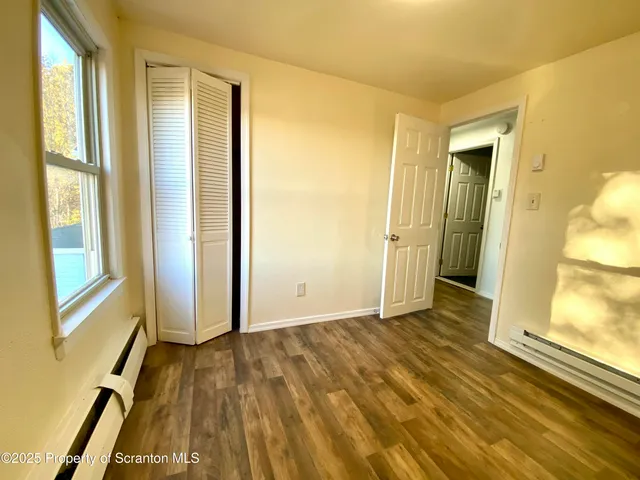 a view of a room with wooden floor and doors