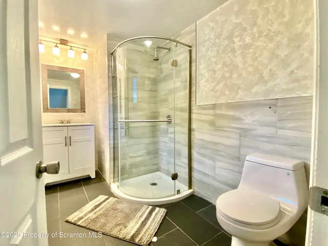 a bathroom with a toilet and a shower