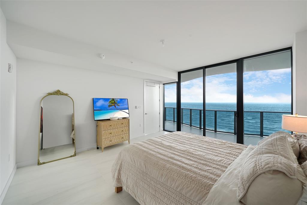 900 North Ocean Boulevard, Unit 906 Pompano Beach, FL 33062 - Photo 9 of 33 a bedroom with a large bed and a large window