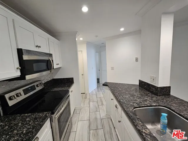 a kitchen with granite countertop a stove and a sink