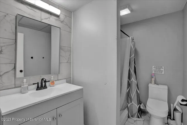 a bathroom with a sink vanity mirror and toilet