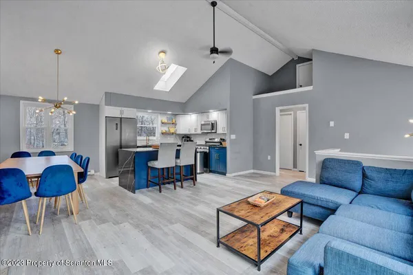 a living room with furniture kitchen view and a chandelier
