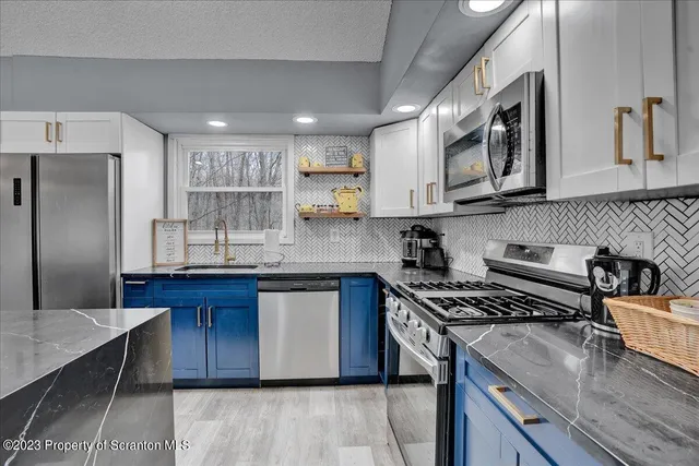 a kitchen with stainless steel appliances granite countertop a sink stove microwave and cabinets