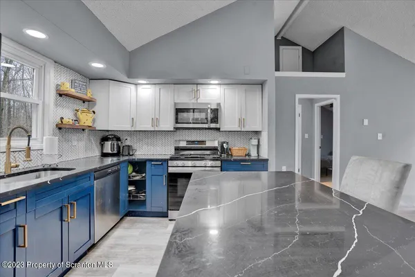 a kitchen with stainless steel appliances granite countertop a sink stove and cabinets