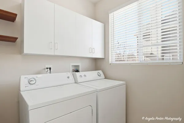 a view of washer and dryer with bathroom in the background
