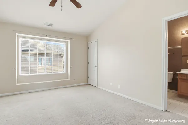 an empty room with ceiling fan and window