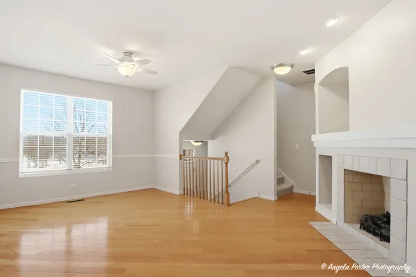 a view of an empty room with a fireplace and a window