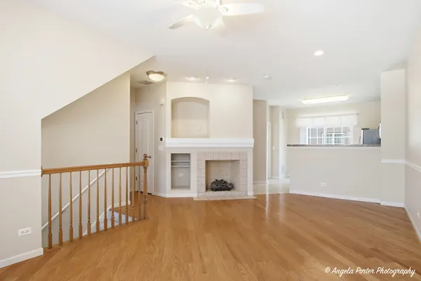 a view of a hallway with wooden floor and a fireplace