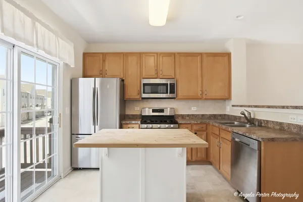 a kitchen with stainless steel appliances a microwave a sink and refrigerator