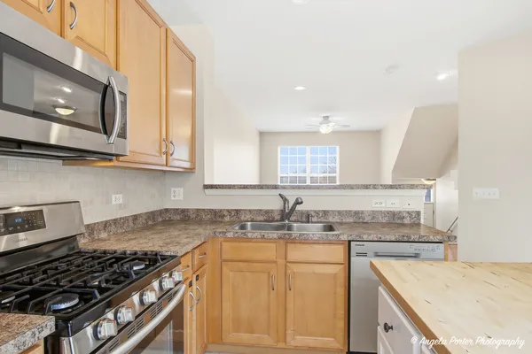 a kitchen with granite countertop a sink a stove and cabinets