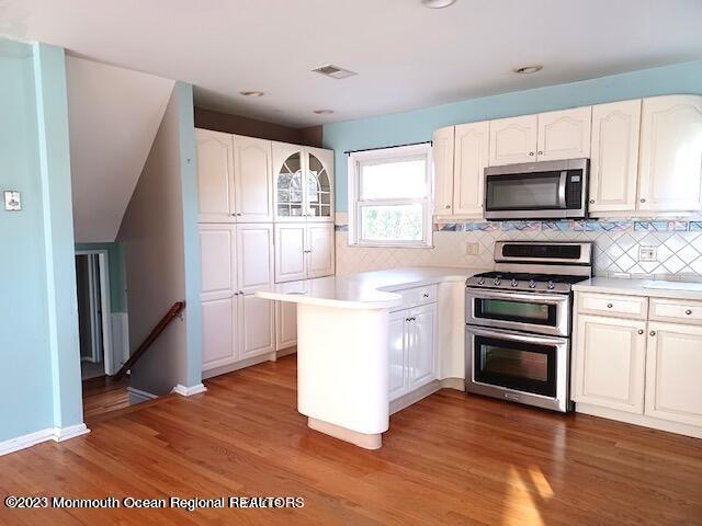 32 Eisele Avenue Asbury Park, NJ 07712 - Photo 12 of 16 a kitchen with wooden floors and stainless steel appliances