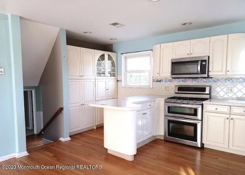 32 Eisele Avenue Asbury Park, NJ 07712 - Photo 16 of 16 a kitchen with stainless steel appliances kitchen island granite countertop a stove a sink and a microwave