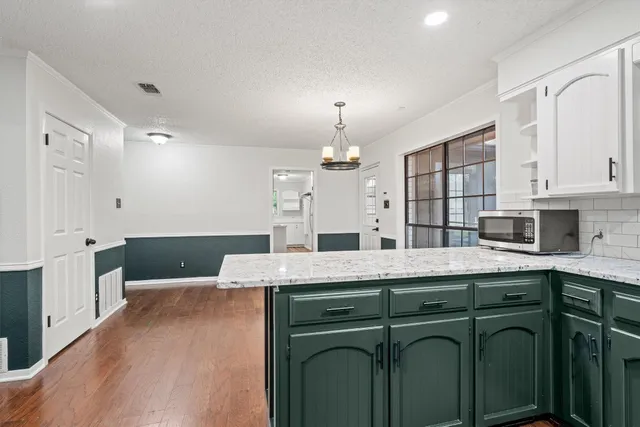 a kitchen with stainless steel appliances a sink a stove a refrigerator cabinets and wooden floor