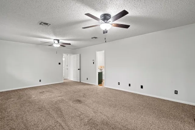 a view of an empty room with wooden floor closet and a window