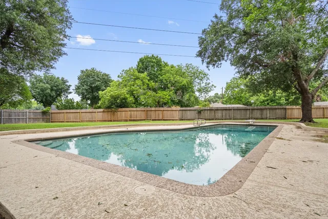 a front view of a house with a yard tree and outdoor seating