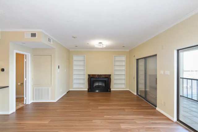 a view of a livingroom with wooden floor and a fireplace