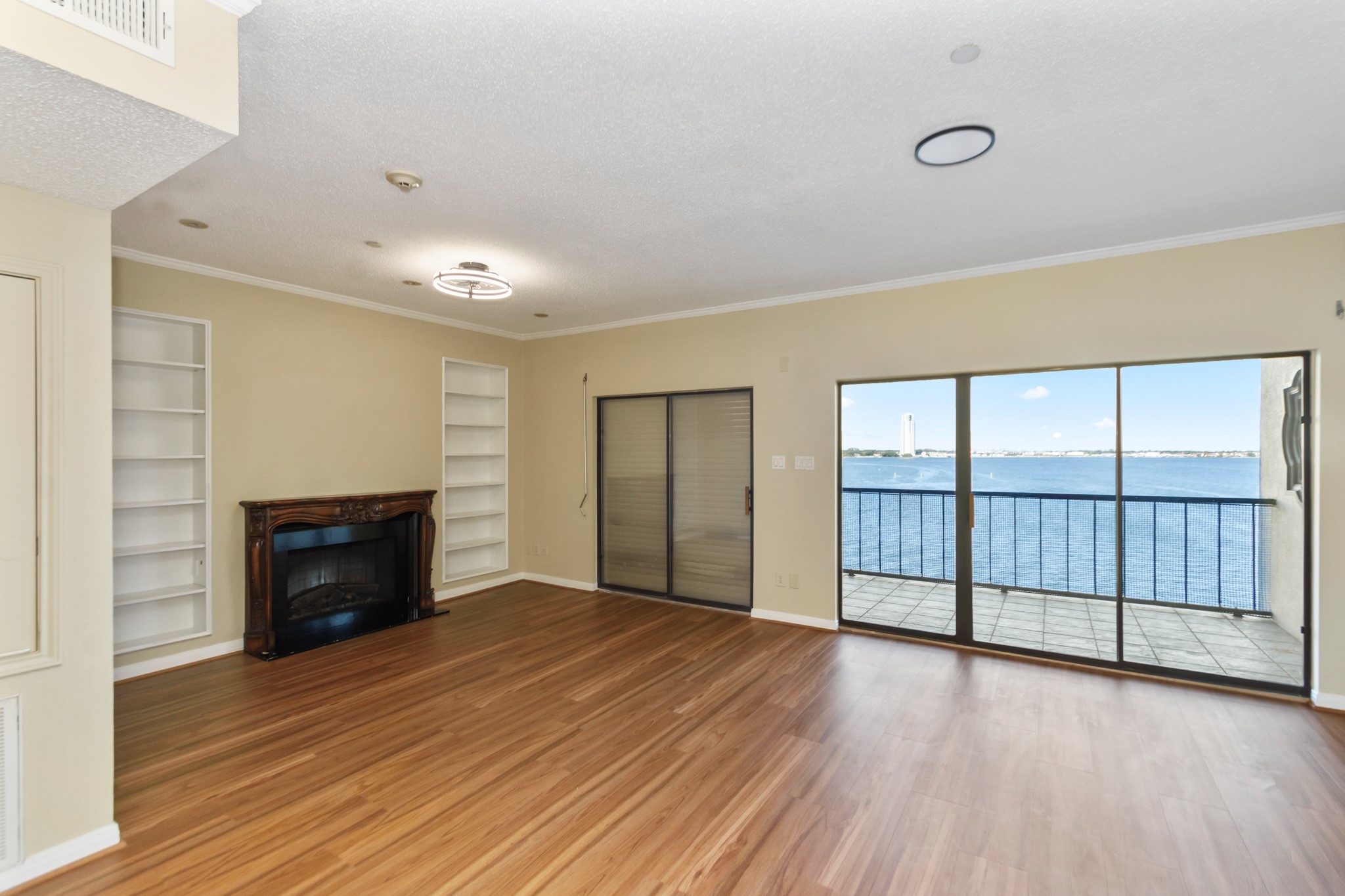 351 Lakeside Lane, Unit 305 Nassau Bay, TX 77058 - Photo 13 of 32 an empty room with wooden floor fireplace and windows