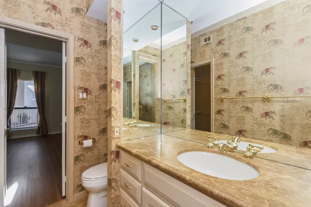 a bathroom with a granite countertop sink toilet a mirror and shower