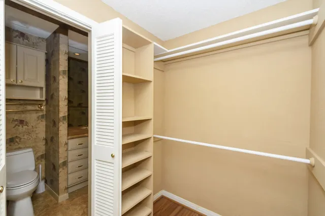 a view of walk in closet with empty racks