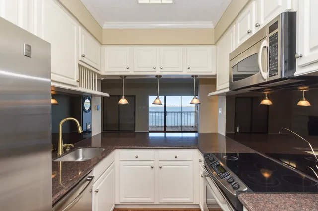 a kitchen with stainless steel appliances granite countertop a sink stove and cabinets