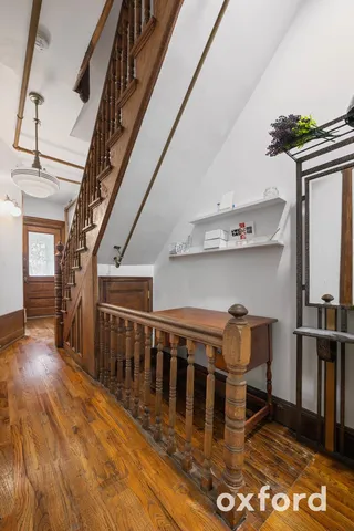 a view of a hallway with wooden floor and staircase