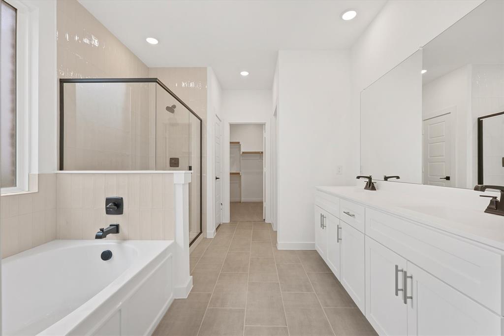 7136 Intrepid Drive Fort Worth, TX 76179 - Photo 19 of 30 a bathroom with a double vanity sink a mirror and a bathtub