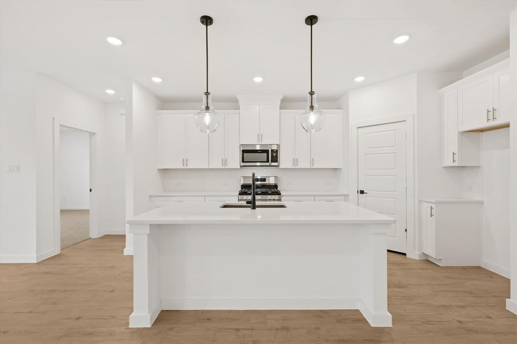 7136 Intrepid Drive Fort Worth, TX 76179 - Photo 7 of 30 a view of a kitchen with kitchen island a chandelier stainless steel appliances and a counter top
