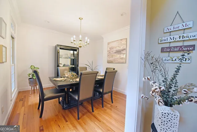 a dining room with furniture a chandelier and wooden floor