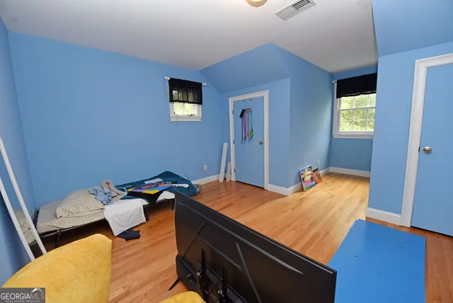 a bed sitting in a spacious bedroom next to a window