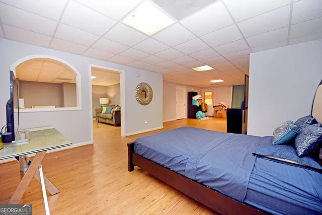 a view of a yard in front of a brick house with plants and large trees