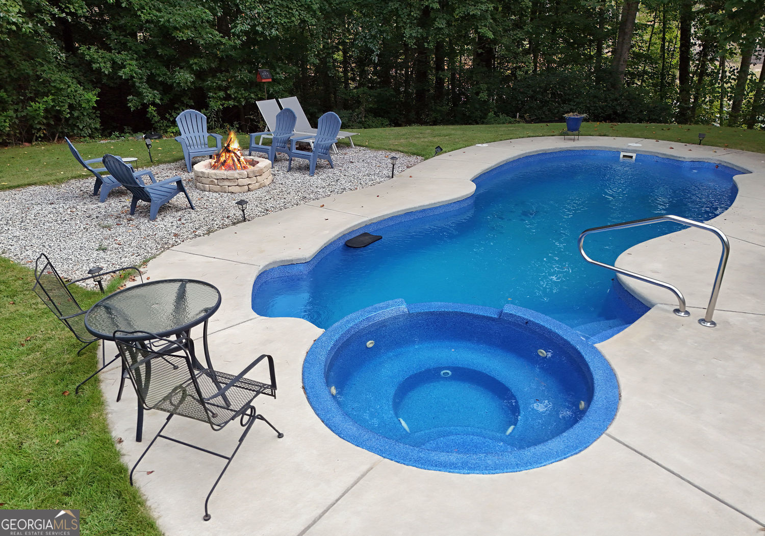 919 Deer Chase Toccoa, GA 30577 - Photo 60 of 62 a view of a swimming pool with a patio and fire pit