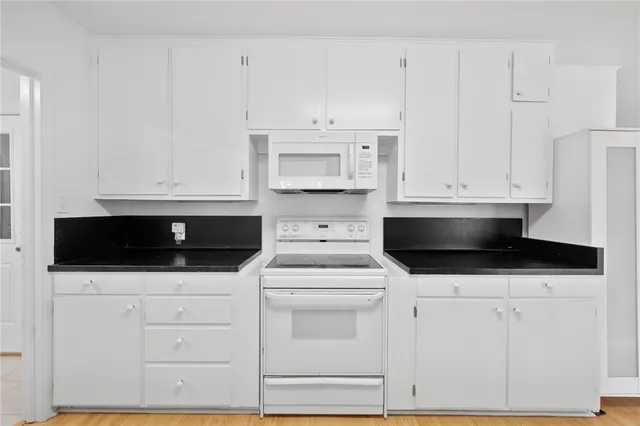 a kitchen with white cabinets and stainless steel appliances