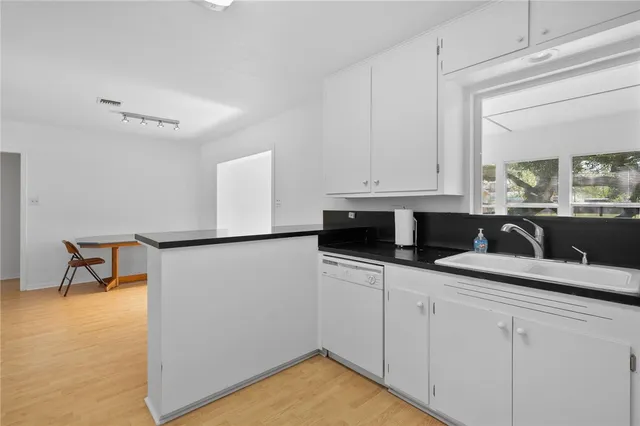 a kitchen with stainless steel appliances white cabinets and a refrigerator